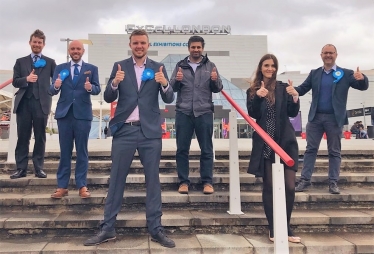 Conservative candidates give a thumbs up outside the Counting centre at ExCel